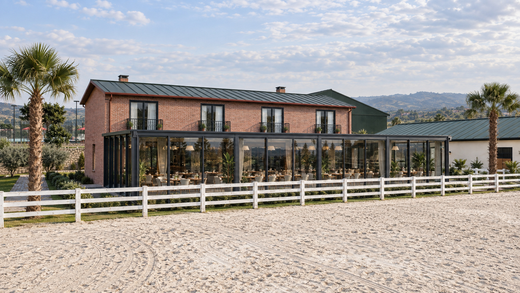 Restoran ve konaklama binası, camlı terası ve önündeki açık manej.